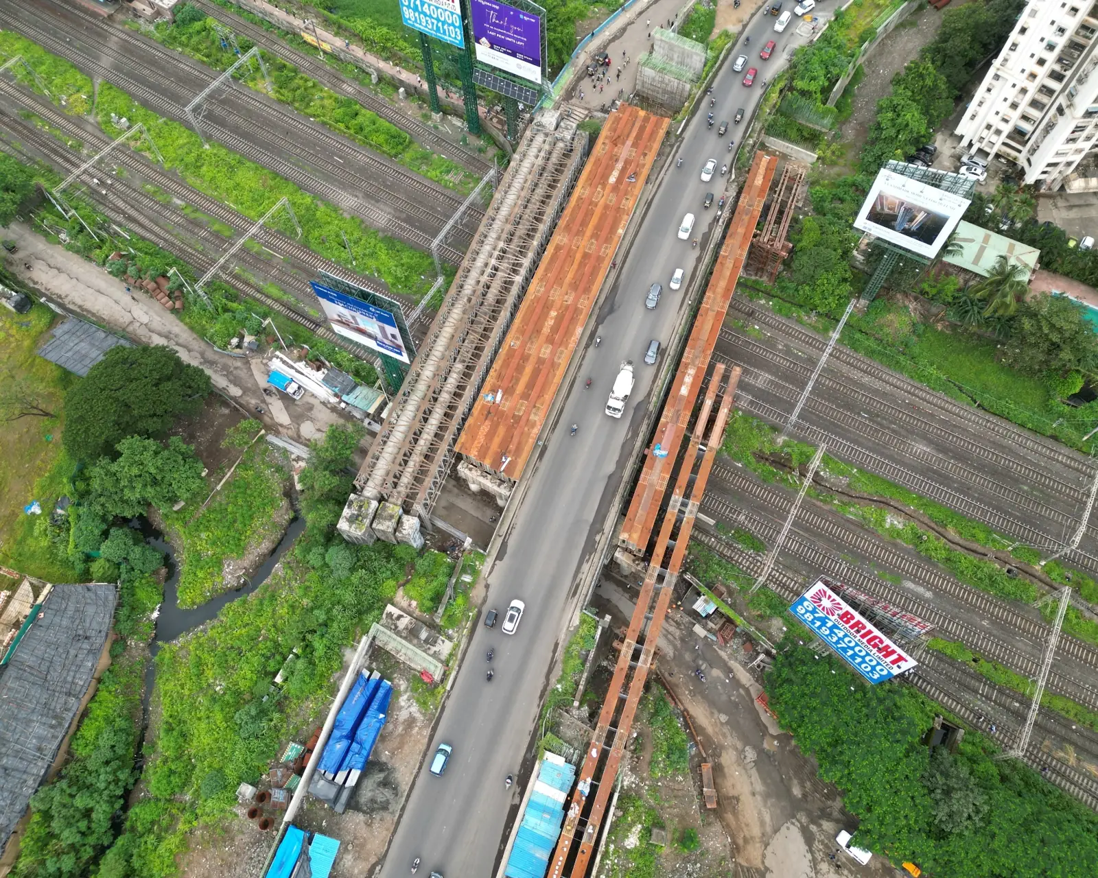 Steel girders spanning a road and rail corridor